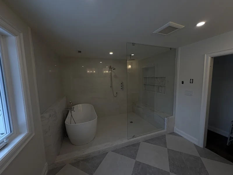 Bathroom with a freestanding tub, glass shower and checkerboard tile floor in Courtice