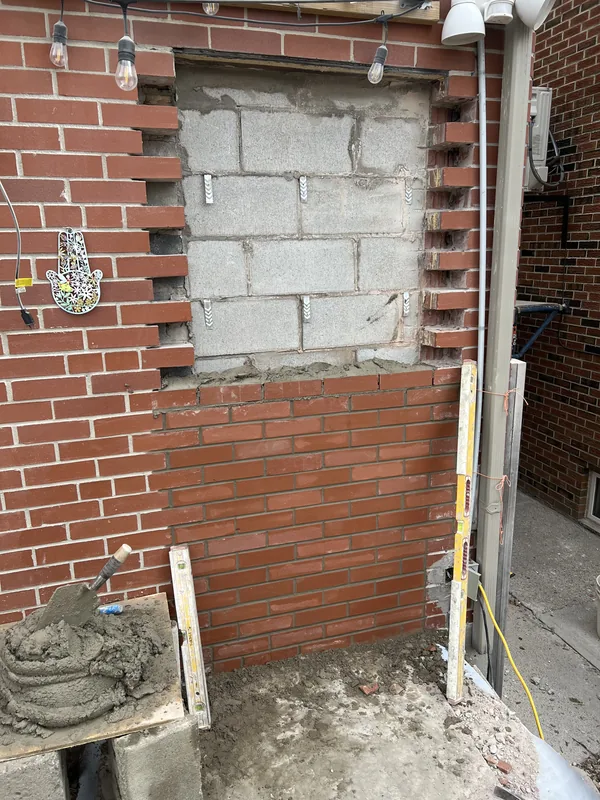Old opening being filled in with matching brick on a Toronto home