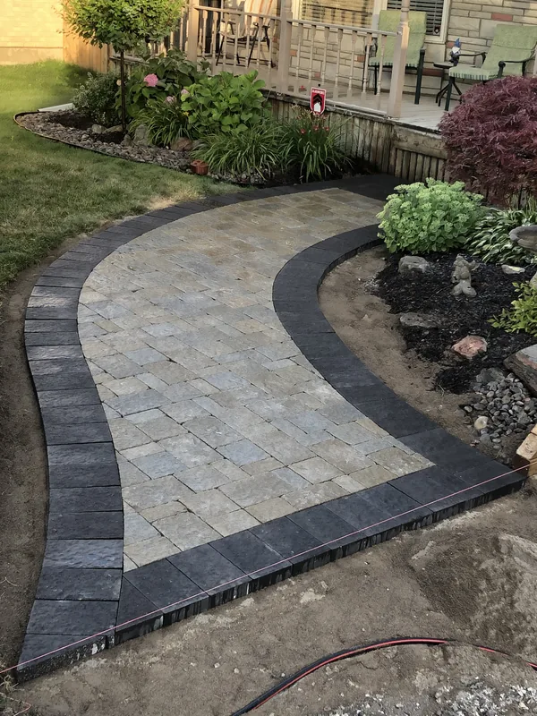 Curved paver walkway with a dark border in Oshawa