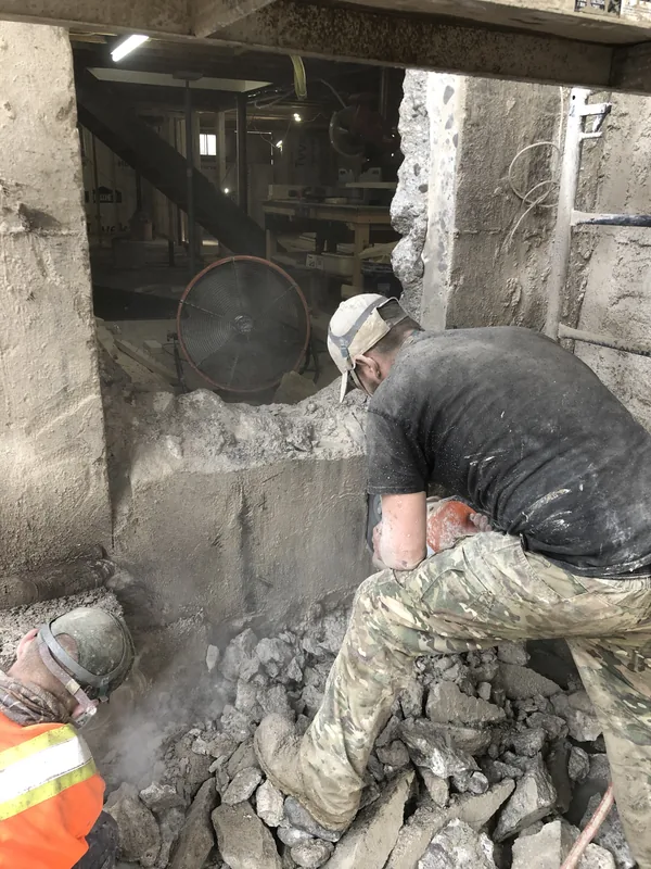 Crew breaking out an old basement wall by hand on an Oshawa job
