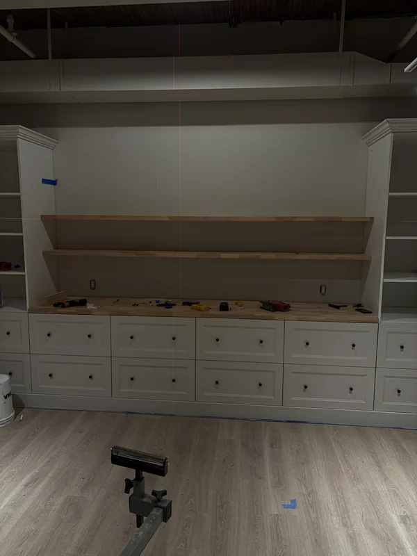 Built-in wall unit with drawers and open shelving being installed