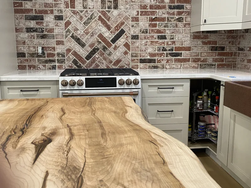 Kitchen with a herringbone brick backsplash and white cabinets