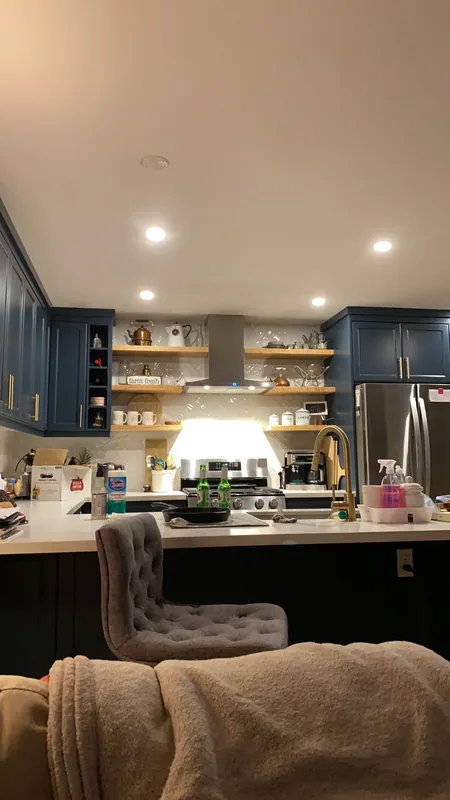 Kitchen with navy cabinets and wood floating shelves