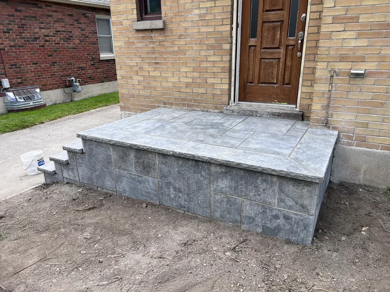 Stone clad front porch with a slab top and side steps in Oshawa