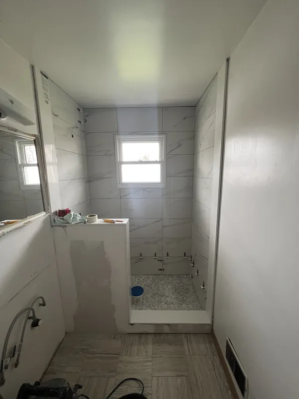 Marble look tiled shower with a half wall in Courtice