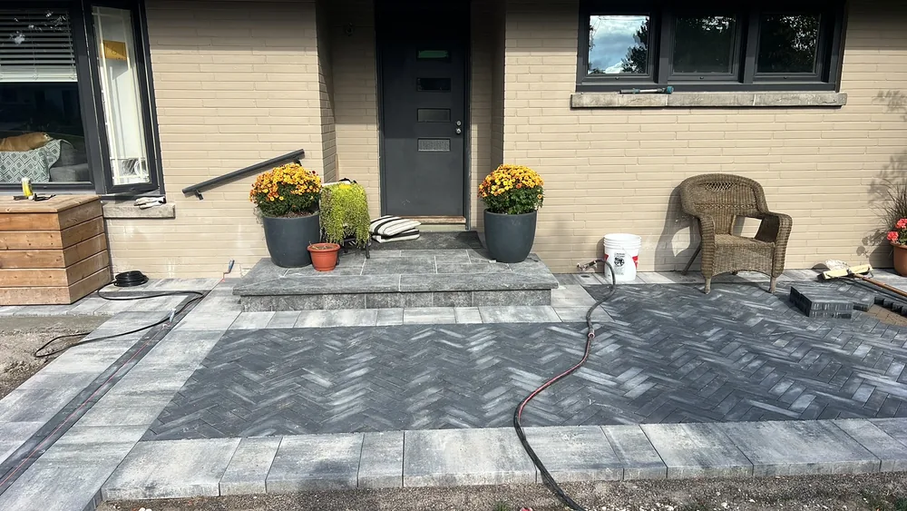 Stone steps and a herringbone paver walkway at a front entrance